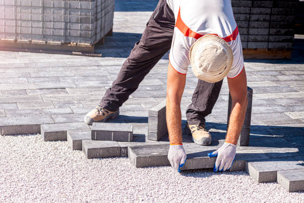 Paver at work. A paver is laying paving stones. Laying concrete paving stones.